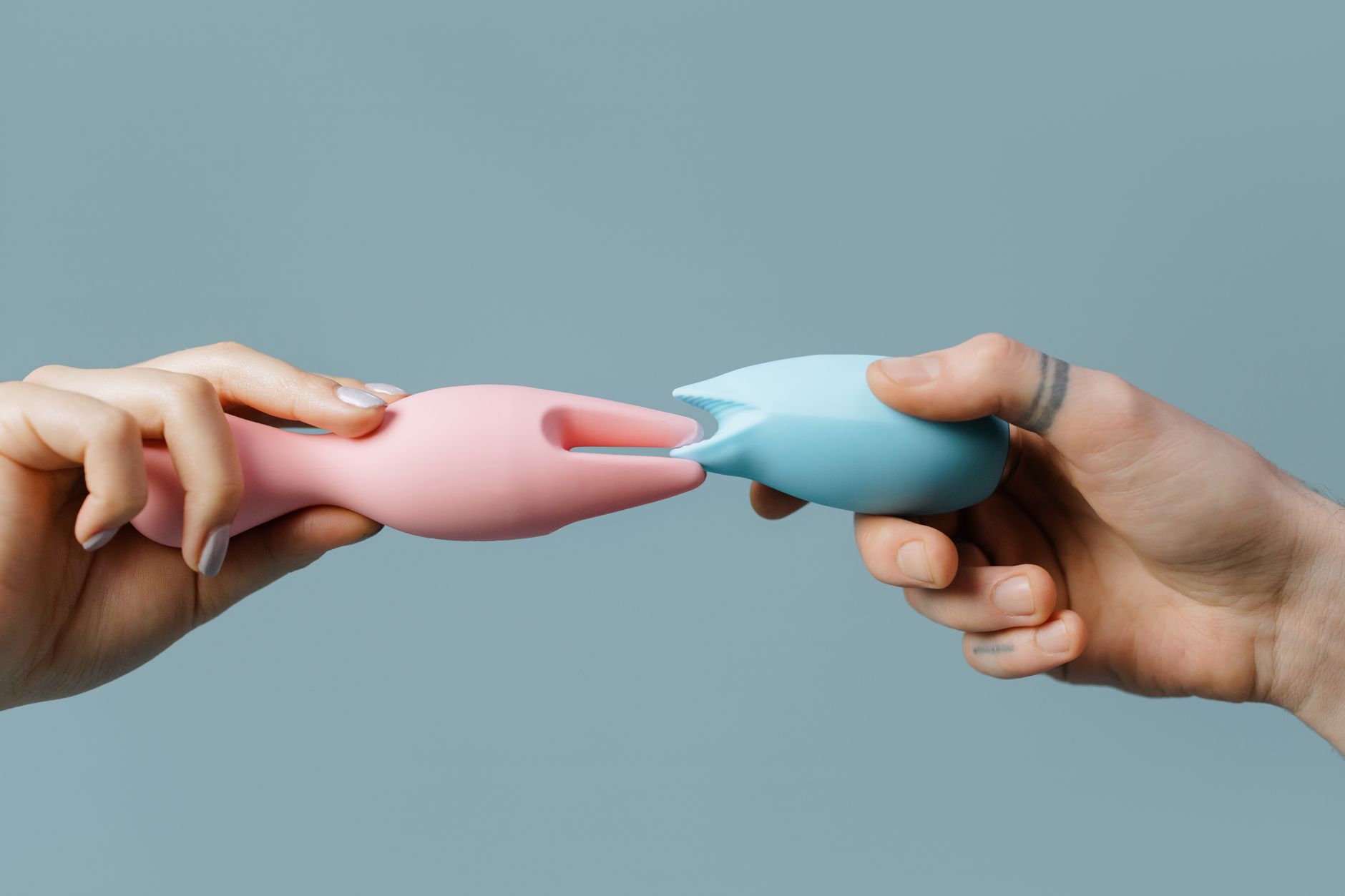 Hand holding a vibrator against a purple background, representing personal pleasure and intimacy