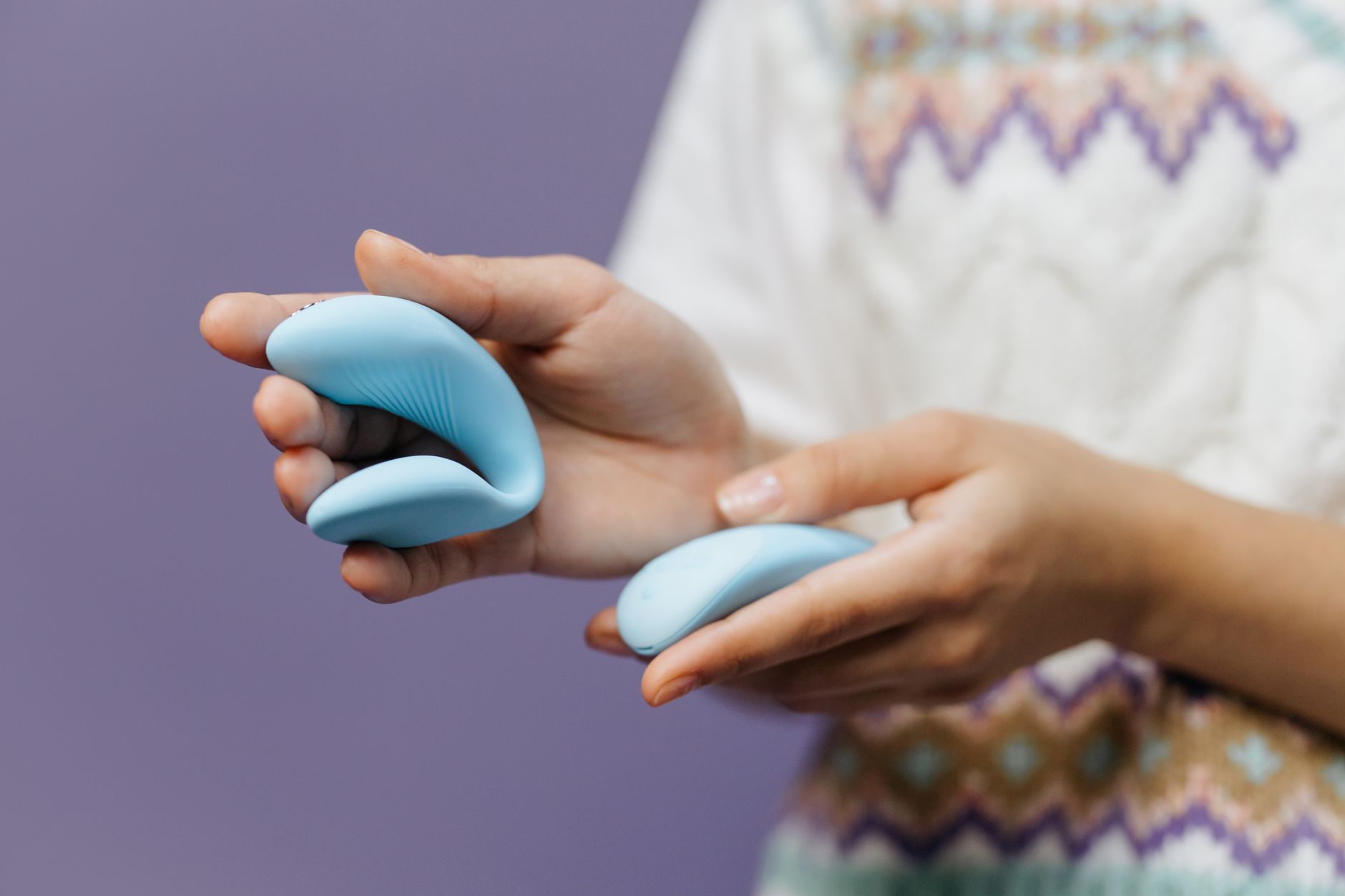 Woman holding blue silicone vibrator in contemplative moment.