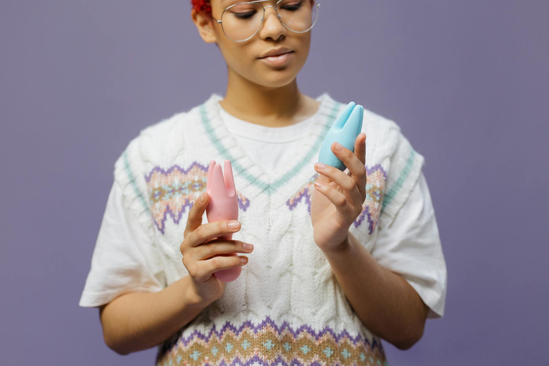 Woman considering two different vibrators thoughtfully, representing the choice between lemon vibrators and traditional options during recovery